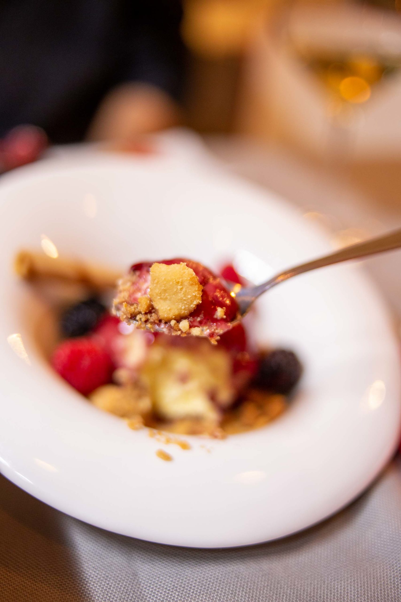 cucchiaio pieno del gelato alla vaniglia con frutti di bosco e streusel